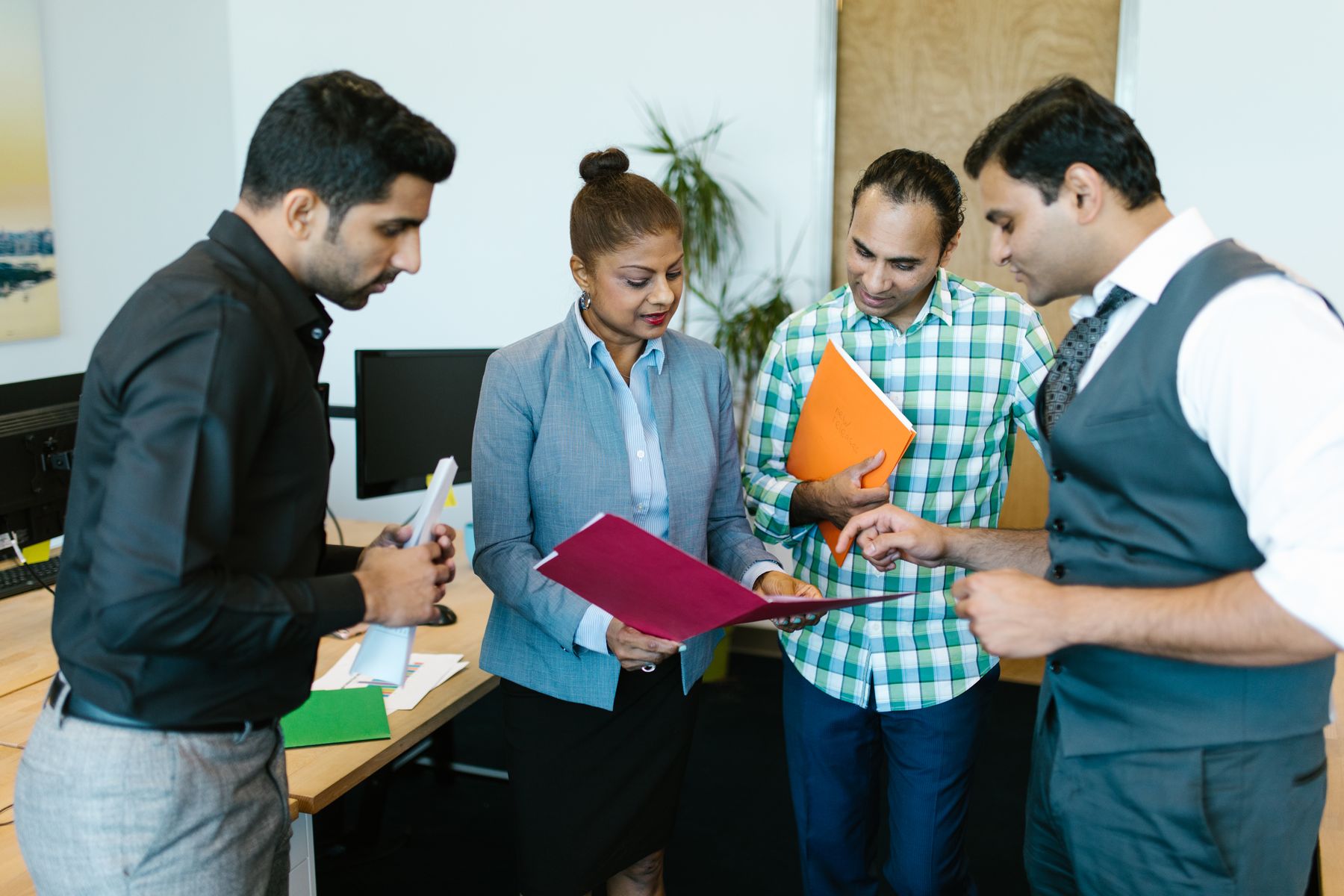 A Pakistani team talking through a plan in their office